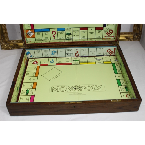 384 - VINTAGE WOODEN CUTLERY BOX WITH A MONOPOLY BOARD PLUS TWO WOODEN FRAMES 
60 X 49CM