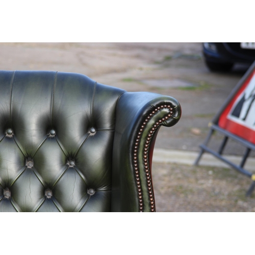 108 - GREEN LEATHER  CHESTERFIELD WINGBACK ARMCHAIR AND FOOTSTOOL
93 X 80 X 106CM