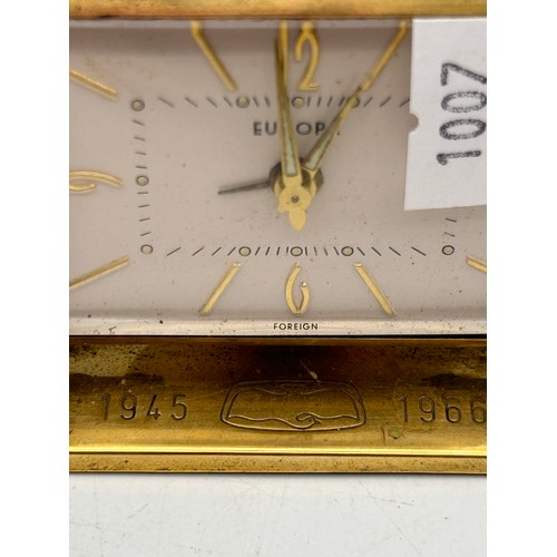 262 - Interesting Little Brass Desk Clock With Birdseye Logo And Dates. Tics When Wound.