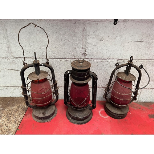 118 - Three Antique oil lamps with ruby shades.