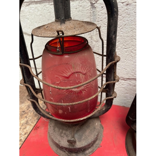 118 - Three Antique oil lamps with ruby shades.