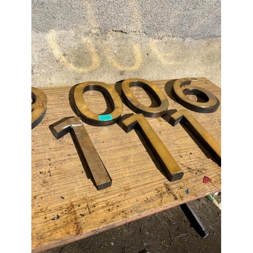 766 - Seven brass plate numbers on mahogany bases. {25 cm H}