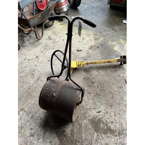 787 - Old garden roller and an old steering wheel on stand.