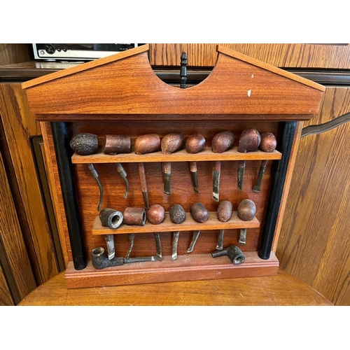 925q - Mahogany pipe rack containing a fine collection of pipes. {Rack 50 cm W x 51 cm H}