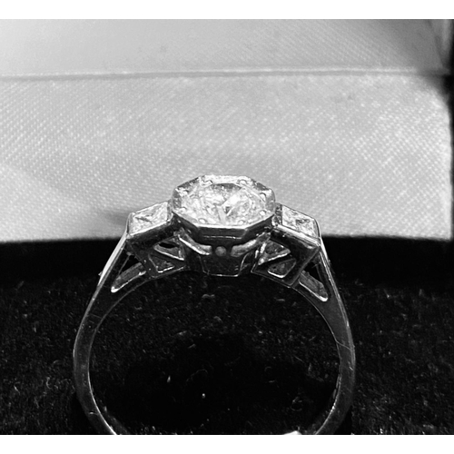 429 - Platinum Diamond Solitaire Ring.  Centre Diamond 1 carat approx with two princess cut diamonds on th... 