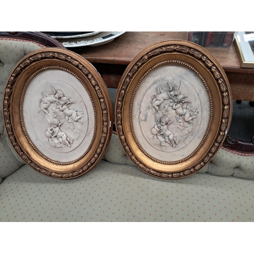 267 - Pair of Oval Framed Decorative Cherus Plaques (54cm x 42cm)