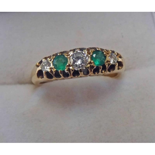 129 - 18CT GOLD EMERALD & DIAMOND 5-STONE RING IN A SCROLL MOUNT