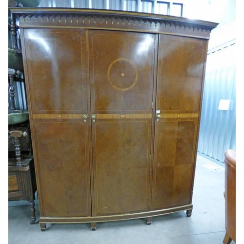 5042 - EARLY 20TH CENTURY BOW FRONT INLAID MAHOGANY TRIPLE DOOR WARDROBE WITH FITTED INTERIOR ON SQUARE SUP... 