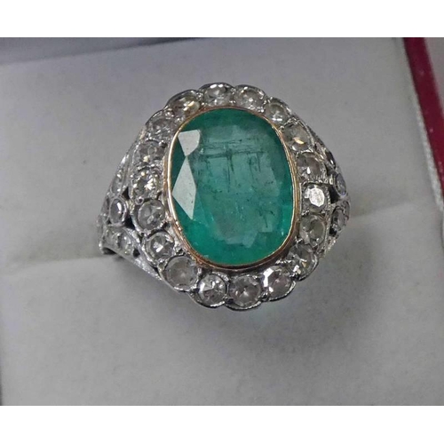 602 - EARLY 20TH CENTURY EMERALD & DIAMOND CLUSTER RING. THE OVAL FACETED EMERALD SET WITHIN A SURROUND OF... 