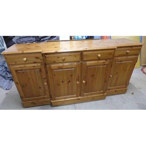 29 - DUCAL PINE BREAKFRONT SIDEBOARD OF 4 DRAWERS OVER 4 PANEL DOORS. WIDTH 174 CM X HEIGHT 88 CM