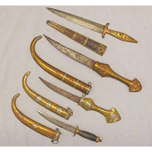 1204 - 4 MIDDLE EASTERN DAGGERS / KNIVES TO INCLUDE A COPPER & BRASS JAMBIYA, WHITE METAL & BRASS JAMBIYA, ... 