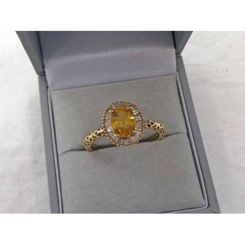 679 - 9K GOLD YELLOW SAPPHIRE & DIAMOND CLUSTER RING, THE OVAL SAPPHIRE APPROX 1.45 CARATS