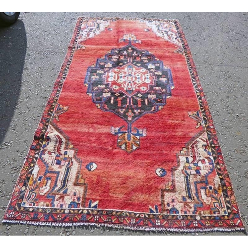 1150 - WASHED RED GROUND PERSIAN SAROUK RUG WITH A LARGE CENTRAL MEDALLION 270 X 132CM