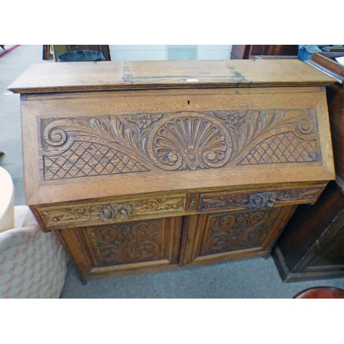 27 - LATE 19TH CENTURY CARVED OAK BUREAU WITH FALL FRONT OVER 2 FRIEZE DRAWERS OVER 2 PANEL DOORS, WIDTH ... 