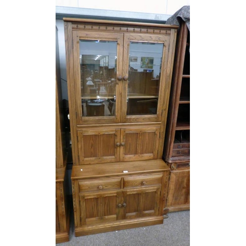 39 - ERCOL ELM CABINET WITH 2 GLASS PANEL DOORS & 2 PANEL DOORS OVER BASE OF 2 DRAWERS OVER 2 PANEL DOORS... 