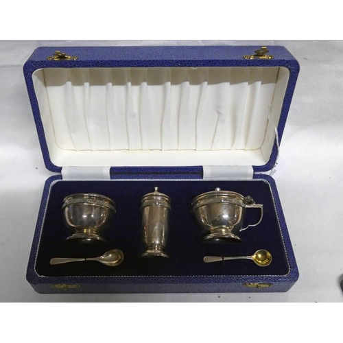 387 - CASED SILVER 3 PIECE CRUET SET WITH CELTIC KNOT DECORATION AND BLUE GLASS LINER, BIRMINGHAM 1975 -12... 