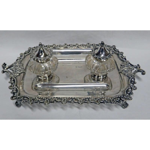 436 - EDWARDIAN SILVER INKWELL STAND WITH PIERCED DECORATIVE BORDER, ON 4 SCROLL SUPPORTS & 2 SILVER MOUNT... 