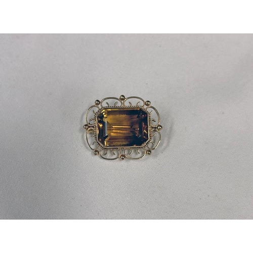 704 - 9CT GOLD CITRINE SET BROOCH WITH DECORATIVE BORDER - 3.2 CM WIDE,  9.6 G