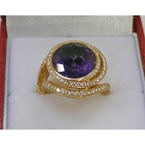 36 - DIAMOND AND AMETHYST GOLD RING, THE CIRCULAR AMETHYST IN A SWIRL OF BRILLIANT CUT DIAMONDS