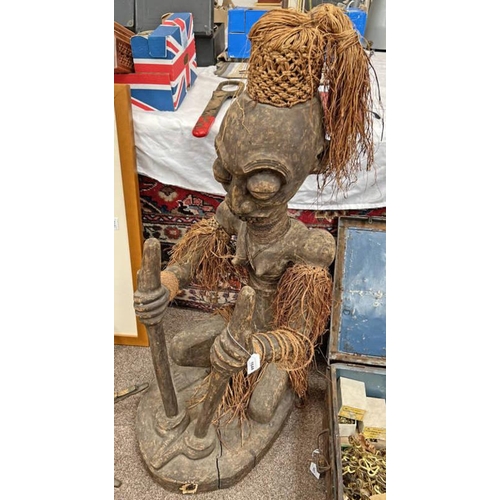 1644 - LARGE AFRICAN CARVED KNEELING FIGURE OF A WOMAN WITH WOVEN AND FRINGED GRASS SKIRT, ARMBANDS, WRISTB... 