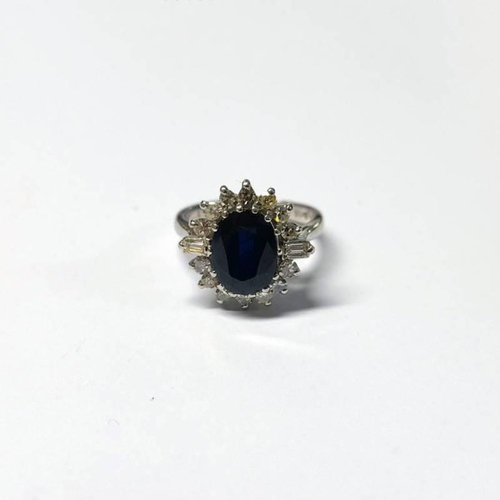 18 - 18CT GOLD SAPPHIRE & DIAMOND CLUSTER RING, THE OVAL FACETED SAPPHIRE SET WITHIN A SURROUND OF ROUND ... 