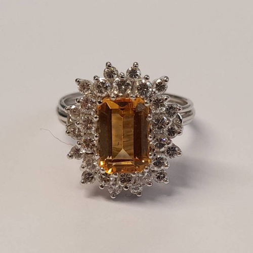 102 - GOLD TOPAZ & DIAMOND CLUSTER RING. THE RECTANGULAR STEP CUT TOPAZ SET WITHIN A SURROUND OF BRILLIANT... 