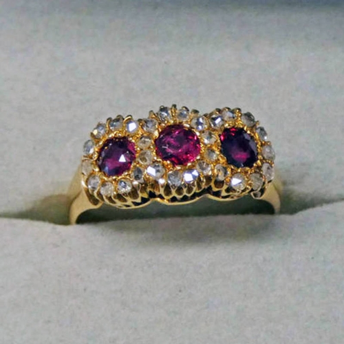 141 - AN EARLY 20TH CENTURY RUBY & DIAMOND RING, THE 3 CIRCULAR CUT RUBIES SET WITHIN 3 CLUSTERS OF ROSE-C... 