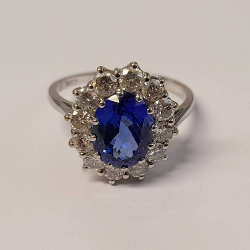 201 - 18CT GOLD TANZANITE & DIAMOND CLUSTER RING, THE OVAL TANZANITE SET WITHIN A SURROUND OF BRILLIANT CU... 