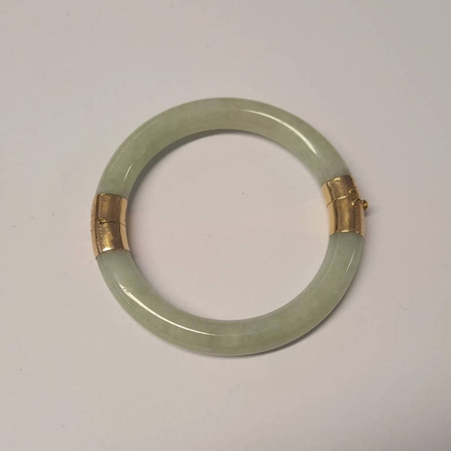 322 - 9CT GOLD MOUNTED JADE HINGED BANGLE - INNER DIAMETER 5.7CM