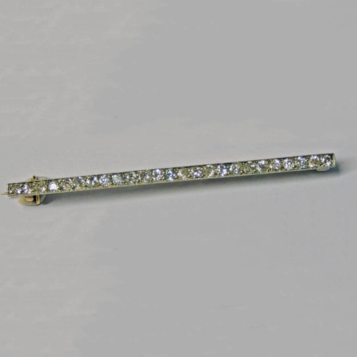 413 - LATE 19TH OR EARLY 20TH CENTURY DIAMOND SET BAR BROOCH IN AN ENGRAVED SETTING APPROX. 1.2 CARATS IN ... 