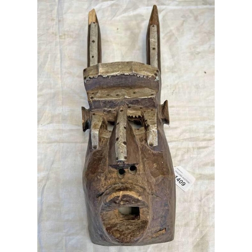 1409 - TRIBAL CARVED WOOD AND METAL MASK, EYES, NOSE AND MOUTH HOLES PRESENT ALONG WITH TWO HORN LIKE PROTR... 