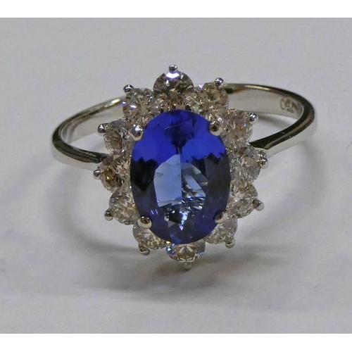 67 - 18 CT GOLD TANZANITE & DIAMOND CLUSTER RING, THE OVAL FACETED TANZANITE SET WITHIN A SURROUND OF 12 ... 