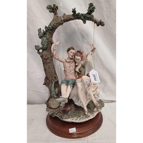 3050 - CONTINENTAL CERAMIC FIGURE OF A COUPLE ON TREE SWING, ON WOODEN BASE