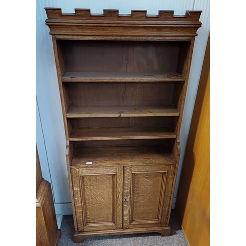 67 - EARLY 20TH CENTURY OAK BOOKCASE WITH CASTELLATED CORNICE OVER SHELVES WITH 2 PANELLED DOORS ON BRACK... 