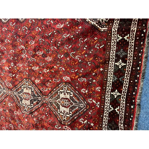 1553 - LARGE RED GROUND MIDDLE EASTERN CARPET BY THE PERSIAN RUG COMPANY, 250 X 360 CM