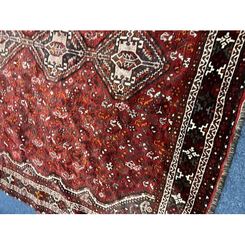 1553 - LARGE RED GROUND MIDDLE EASTERN CARPET BY THE PERSIAN RUG COMPANY, 250 X 360 CM