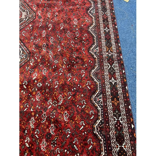 1553 - LARGE RED GROUND MIDDLE EASTERN CARPET BY THE PERSIAN RUG COMPANY, 250 X 360 CM