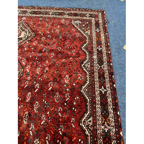 1553 - LARGE RED GROUND MIDDLE EASTERN CARPET BY THE PERSIAN RUG COMPANY, 250 X 360 CM