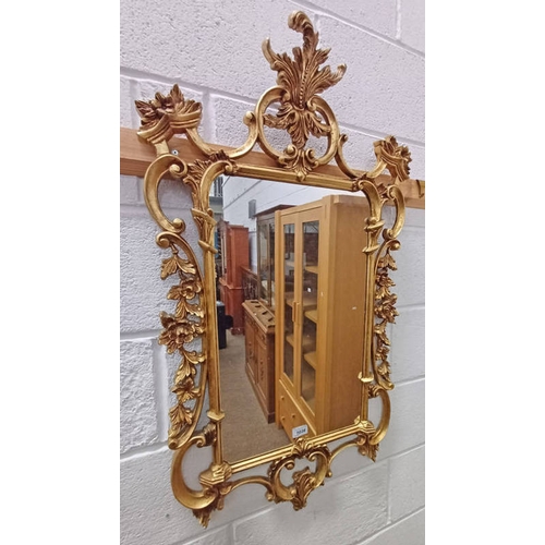 1038 - GILT WALL MIRROR WITH FLORAL DESIGN TO FRAME, APPROX. 59 X 35 CM, (INSIDE FRAME) BY MORRIS MIRRORS