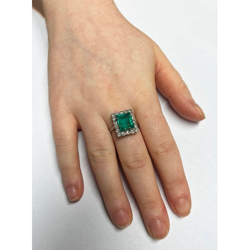 1 - A PLATINUM EMERALD & DIAMOND CLUSTER RING, THE RECTANGULAR CUT EMERALD SET WITHIN A SURROUND OF 18 D... 