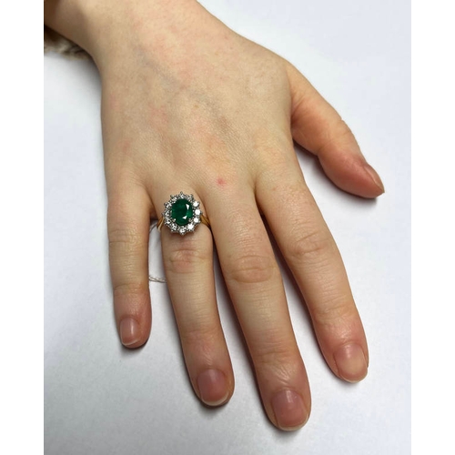 149 - 18CT GOLD EMERALD & DIAMOND CLUSTER RING, THE OVAL CUT EMERALD SET WITHIN A SURROUND OF 12 CIRCULAR ... 