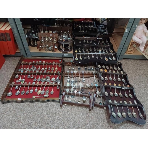 3069 - VERY LARGE SELECTION OF CRESTED SPOONS, ETC IN VARIOUS WOODEN RACKS & STANDS ON 1 SHELF