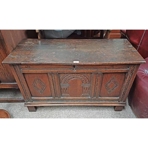 67 - 18TH / 19TH CENTURY OAK COFFER WITH DECORATIVE CARVED PANEL FRONT ON BLOCK FEET