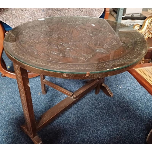 126 - EASTERN HARDWOOD FLIP TOP CIRCULAR TABLE WITH CARVED ORIENTAL SCENE DECORATION TO TOP