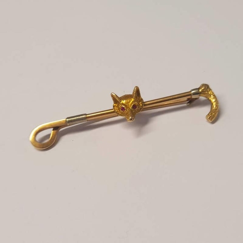 115 - 14CT GOLD RIDING CROP & FOX HEAD BROOCH, SET WITH RUBIES - 6.2CM LONG, 8.1G