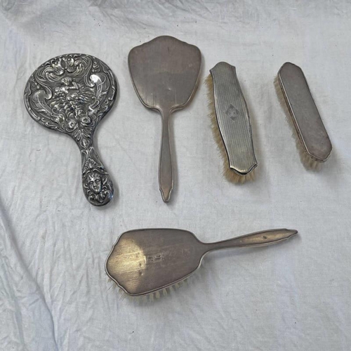 132 - 4 SILVER MOUNTED BRUSHES & SILVER HAND MIRROR WITH CHERUB DECORATION