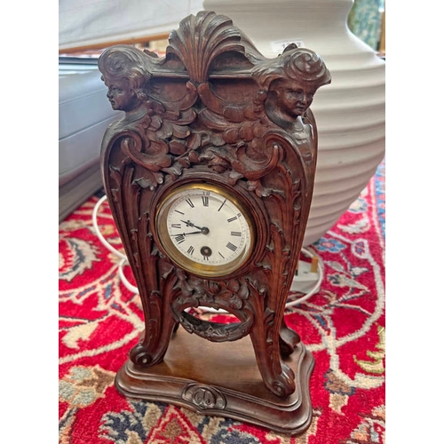 1273 - EARLY 20TH CENTURY HEAVILY CARVED WALNUT CLOCK, FRONT CARVED WITH SCROLLING FOLIAGE AND FACES, REAR ... 