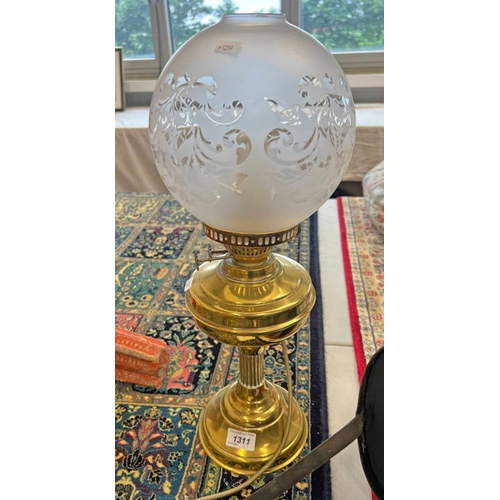 1311 - BRASS BODIED PARAFFIN LAMP CONVERTED TO ELECTRICITY WITH A FROSTED GLASS SHADE. 51CM TALL