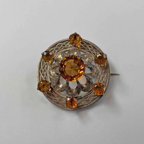 264 - SCOTTISH SILVER CITRINE SET CIRCULAR BROOCH WITH CELTIC PATTERN DECORATION - 4.5CM DIAMETER