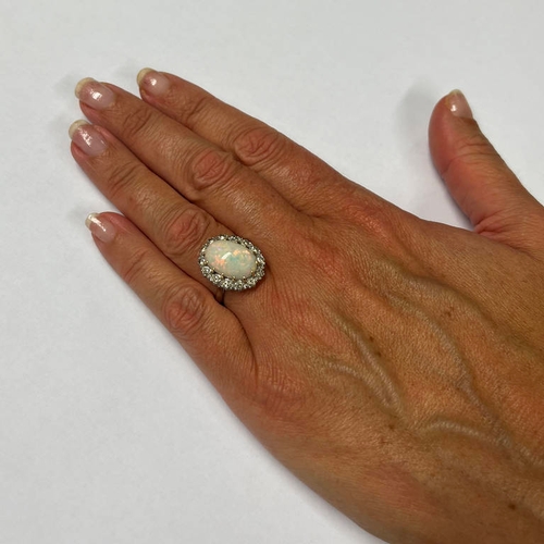 60 - OPAL & DIAMOND CLUSTER RING, THE OVAL CABOCHON SET WITH A SURROUND OF BRILLIANT CUT DIAMONDS APPROX.... 